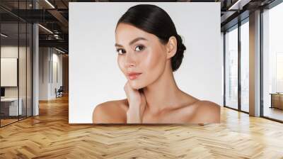 Beauty portrait of charming caucasian woman with brown hair in bun posing at camera with beautiful look, isolated over white background Wall mural