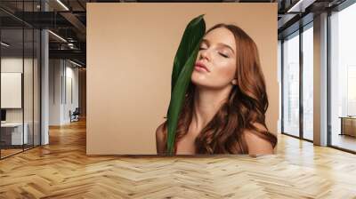 Beauty portrait of ginger woman with long hair posing Wall mural