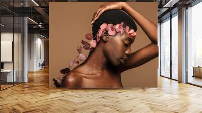 Beauty portrait of young half-naked african woman holding exotic flower Wall mural