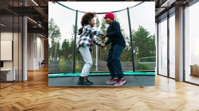 Black two boys making fun while jumping in bounce house Wall mural