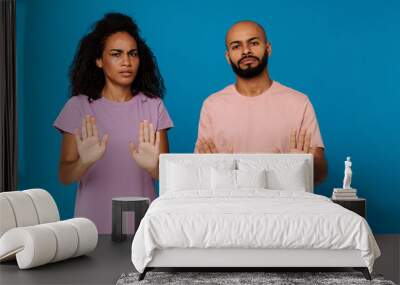 Black young man and woman making stop gesture at camera Wall mural