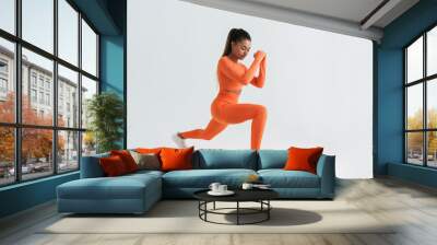 Black young sportswoman doing exercise while working out Wall mural