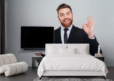 Business man showing blank laptop screen Wall mural