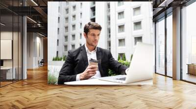 businessman working with laptop and drinking coffee outdoors Wall mural