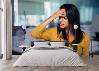 businesswoman having headache in office Wall mural