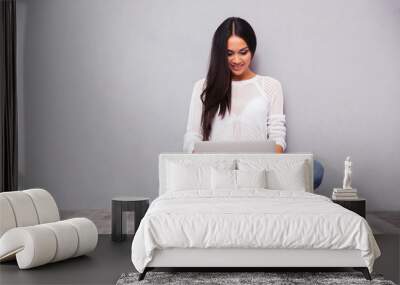 Casual woman sitting on the floor with laptop Wall mural