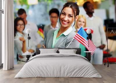 Cheerful businesswoman holding flag of USA  Wall mural