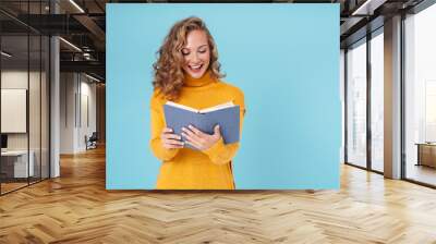 Cheerful lovely young girl wearing sweater standing Wall mural