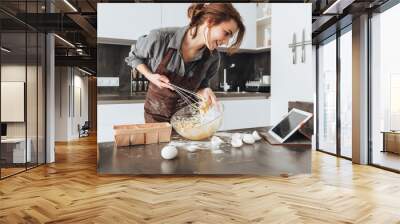 cheerful woman cooking and looking at tablet computer. Wall mural