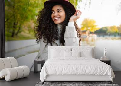 Cheerful young african woman wearing coat riding in a boat Wall mural