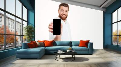 Cheerful young bearded emotional man showing display of phone. Wall mural