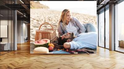 Cheerful young couple in love having picnic Wall mural