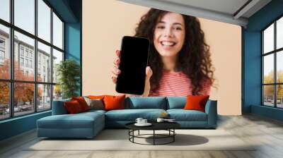 Cheerful young girl with dark curly hair Wall mural