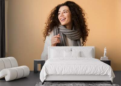 Cheerful young woman wearing winter scarf Wall mural