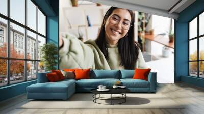 Cheery optimistic young girl student indoors take a selfie Wall mural