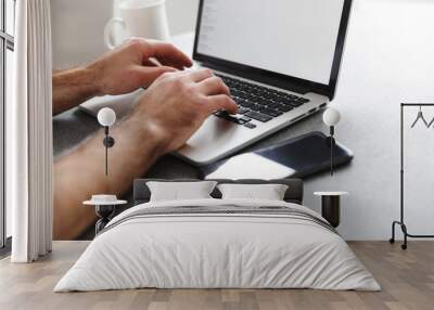 Close up of a man typing on laptop computer Wall mural