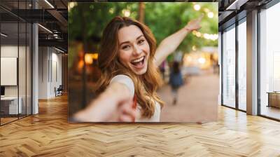 Close up of cheerful young girl pointing away Wall mural