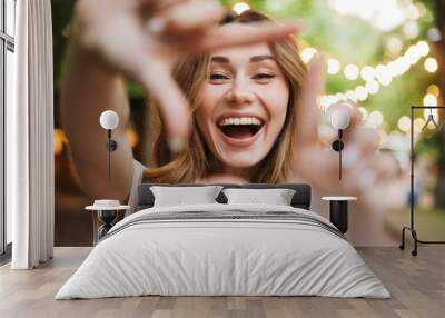 close up of happy young girl showing frame with fingers Wall mural