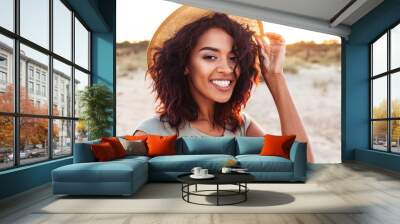 Close up of smiling young african girl in summer hat Wall mural