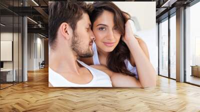 Close-up portrait of a beautiful kissing couple in bed Wall mural