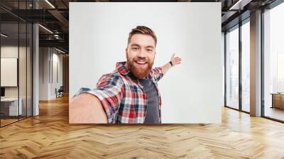 Close up portrait of a cheerful bearded man taking selfie Wall mural