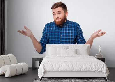 Confused young bearded man standing Wall mural