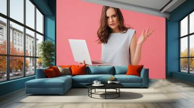 Confused young woman using laptop computer. Wall mural