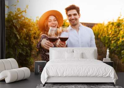 Cute happy loving couple outdoors drinking wine looking camera. Wall mural