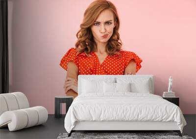 Displeased offended young woman posing isolated over pink wall background. Wall mural