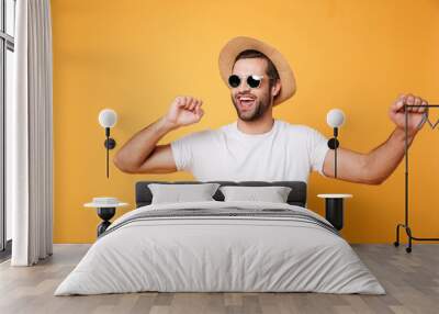 emotional man in summer hat looking aside isolated dancing. Wall mural