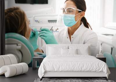 European mid dentist woman in face mask working in dental clinic Wall mural