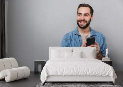 Excited cheerful man wearing shirt standing isolated Wall mural