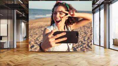 Excited young girl taking a selfie Wall mural