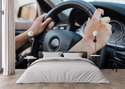 Female hands on steering wheel while driving a car Wall mural