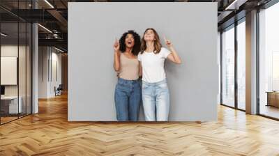 Full length portrait of two cheerful young women Wall mural