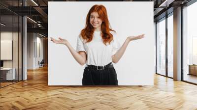 Ginger beautiful joyful girl smiling and holding copyspace Wall mural