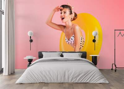 Gorgeous young pin-up woman in swimwear with inflatable ring. Looking aside. Wall mural