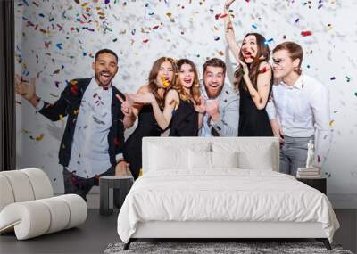 Group of cheerful joyful young people standing and celebrating together Wall mural