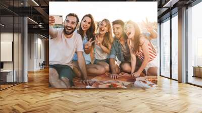 Group of happy friends spending time together at the beach Wall mural