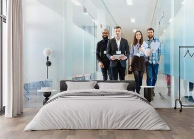 Group of happy young business people walking in office together Wall mural