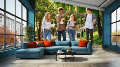 Group of laughing students walking at the campus Wall mural