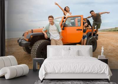 Group of young happy people standing near their car Wall mural