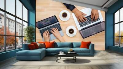 Hands of african man and caucasian woman typing on laptops Wall mural