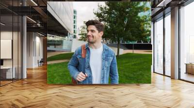 Handsome young man dressed casually spending time outdoors Wall mural