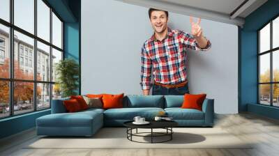 Handsome young man showing victory fingers sign Wall mural