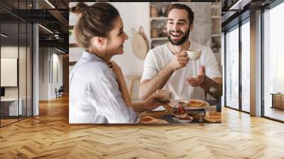 Happy cheerful couple having tasty breakfast Wall mural