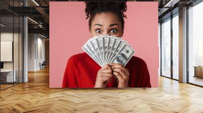 Happy excited young african woman posing isolated over pink wall background holding money. Wall mural