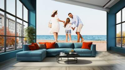 Happy family having fun together at the beach. Wall mural