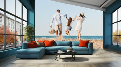 Happy family having fun together at the beach. Wall mural