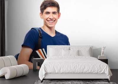 Happy male student with backpack and books holding laptop isolated on a white background. Looking at camera Wall mural